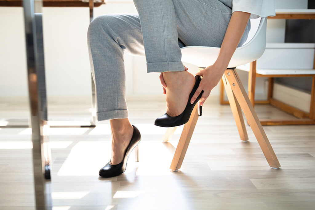 Young Businesswoman Suffering From Leg Pain Because Of Shoes