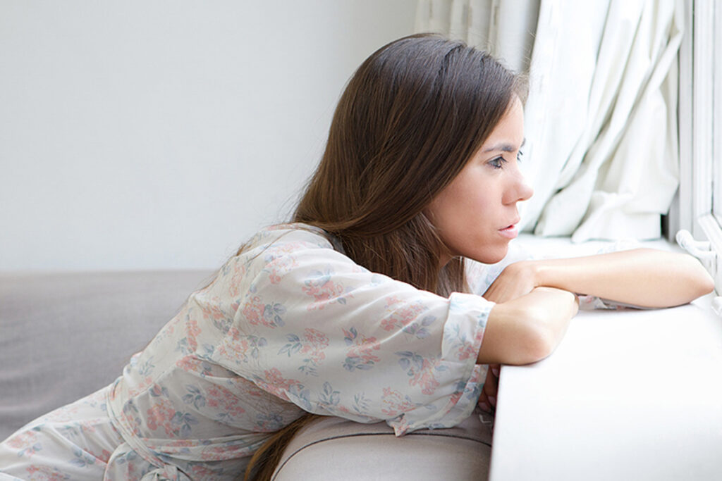 Young Woman Sitting Alone Looking Out Window